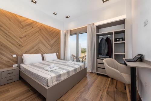 a bedroom with a bed and a desk and a window at Kimia Luxury Apartments in Kolymbia