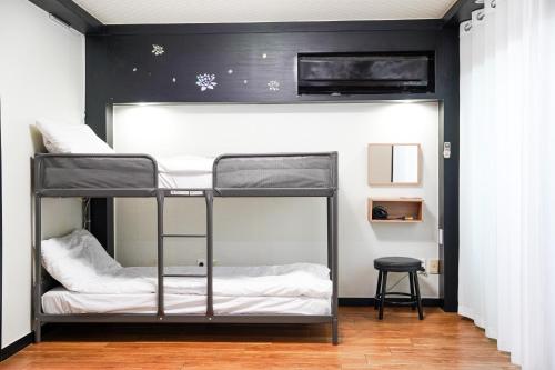 Cette chambre dispose de lits superposés et de 2 lits superposés. dans l'établissement ttottot Jeju Backpackers, à Seogwipo