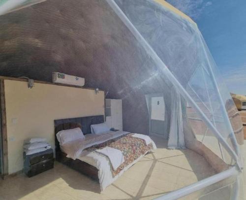 a small bedroom with a bed in a tent at wadi rum camp stars & jeep tour in Wadi Rum