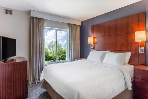 a hotel room with a bed and a window at Residence Inn Duluth in Duluth