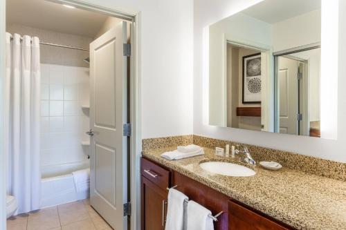 Residence Inn Duluth في دولوث: حمام مع حوض ومرآة