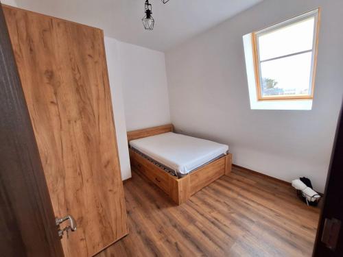 a small room with a bed and a window at Апартамент БОХО Приморско in Primorsko