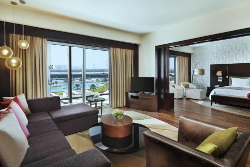 a living room with a couch and a bed and a television at Marriott Hotel Al Forsan, Abu Dhabi in Abu Dhabi