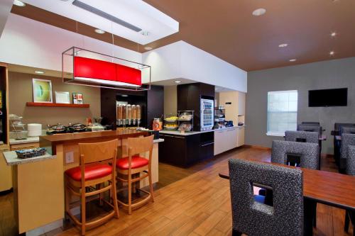 a kitchen with a bar with chairs and a counter at TownePlace Suites Fort Worth Southwest TCU Area in Fort Worth