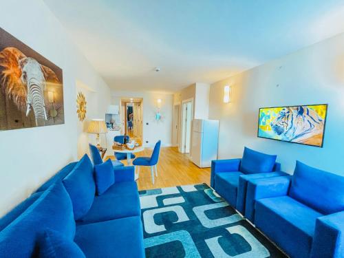 a living room with a blue couch and blue chairs at Batumi High View in Batumi