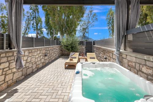 a jacuzzi tub on a patio with a table at Kimia Luxury Apartments in Kolymbia