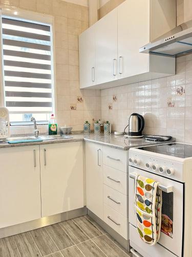 a kitchen with white cabinets and a stove top oven at Maria & Matthias - Apartments in Central of Floriana in Il-Furjana