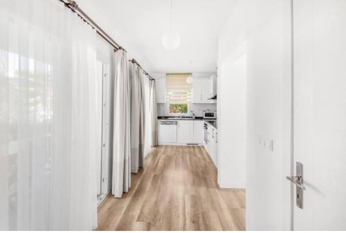 a kitchen with white walls and a wooden floor at Dibek Homes Villa & Hotel in Yalıkavak