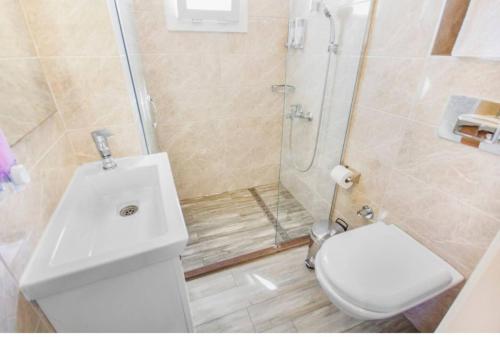 uma casa de banho com um chuveiro, um WC e um lavatório. em Dibek Homes Villa & Hotel em Yalıkavak