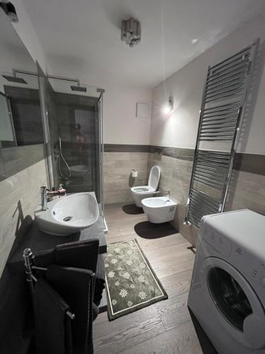 a bathroom with two sinks and a washing machine at Dolomites Holiday Home in Canazei