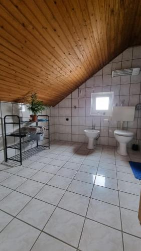 uma casa de banho com 2 WC, uma mesa e um lavatório em U Bloku em Donji Miholjac