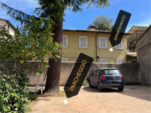 een auto geparkeerd voor een boom met borden bij Charme in Centro with private parking in Ascoli Piceno