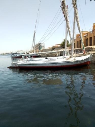 una barca a vela è ormeggiata in acqua di Ozzy Tourism a Aswan