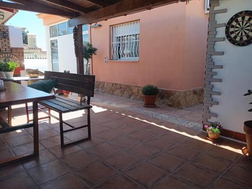 un patio con banco, mesa y ventana en La casa de huespedes en Puebla de Vallbona