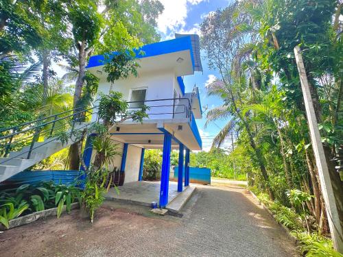 a blue and white house with a staircase outside at Jungle Fence in Bentota