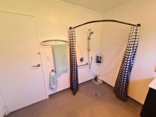 a bathroom with a shower and a shower curtain at Hilltop Blue Sky House in Porirua