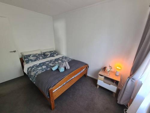 a bedroom with a bed with two stuffed animals on it at Hilltop Blue Sky House in Porirua