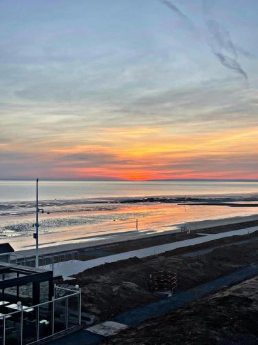 - une vue sur la plage au coucher du soleil sur l'océan dans l'établissement STUDIO DDAY, à Langrune-sur-Mer