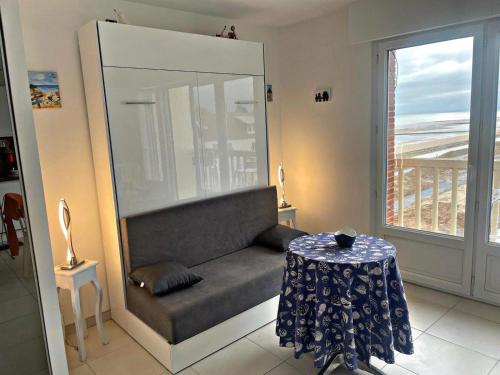une pièce avec une chaise, une table et une fenêtre dans l'établissement STUDIO DDAY, à Langrune-sur-Mer