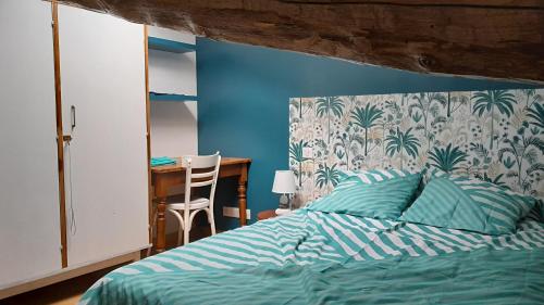 une chambre avec un lit avec un mur bleu dans l'établissement gite du lavoir, à Meximieux