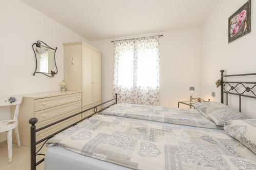 a bedroom with two beds and a dresser and a window at Ciliegia in Tignale
