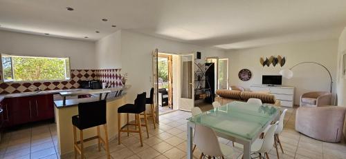 une cuisine et un salon avec une table et des chaises dans l'établissement Rez-de-villa T4, idyllique et indépendant, à Olmeto