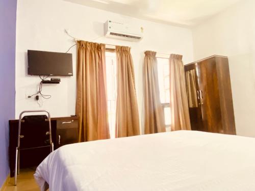 a bedroom with a bed and a flat screen tv at Relaxing 4 Bedroom AC Near Pune Airport Free Wifi in Pune