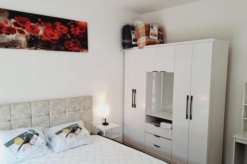 - une chambre avec une armoire blanche et un lit dans l'établissement Appartement près de Paris, à Cergy