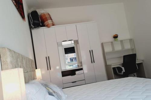- une chambre avec un lit, des armoires blanches et une fenêtre dans l'établissement Appartement près de Paris, à Cergy