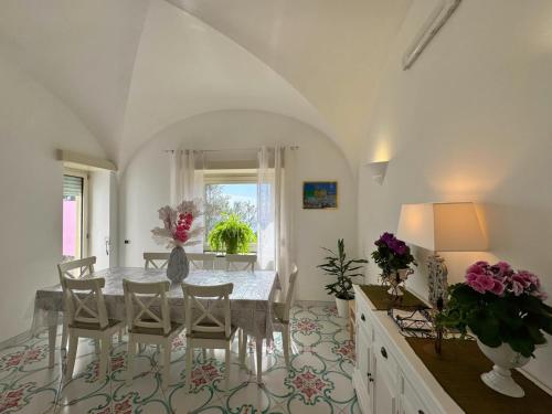 uma sala de jantar branca com uma mesa e cadeiras em Villa Azul em Anacapri