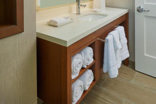 a bathroom with a sink and towels under a counter at Residence Inn by Marriott Oahu Kapolei in Kapolei