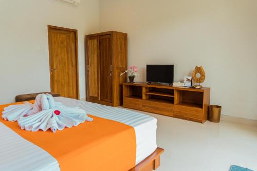 ein Schlafzimmer mit einem Bett mit einer orangen und blauen Decke in der Unterkunft Villa Nugraha Lovina Private Pool in Singaraja