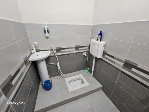 uma casa de banho com um WC e um lavatório em SYED Rest House em Karachi