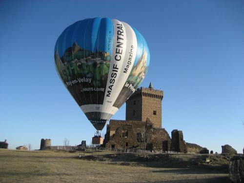 a hot air balloon flying in front of a castle at ibis budget Le Puy En Velay in Le Puy en Velay
