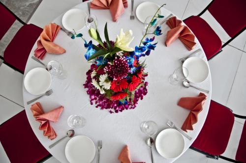 a white table with a floral arrangement on it at The Opal in Rāmpur