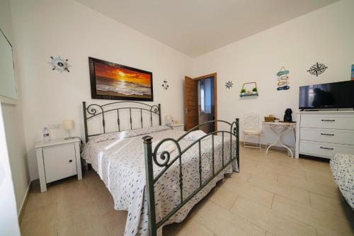 1 dormitorio con 1 cama y TV de pantalla plana en Il Poggetto di Porto Ercole, en Porto Ercole