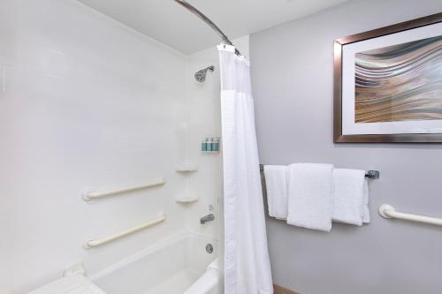 a bathroom with a tub and a toilet and towels at Courtyard by Marriott Lexington North in Lexington