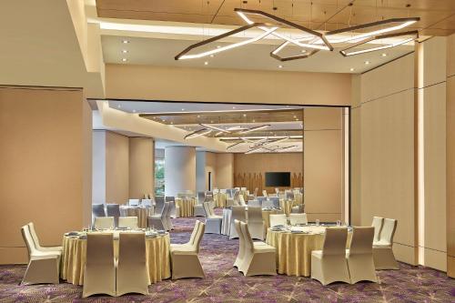 a banquet hall with tables and white chairs at Renaissance Kuala Lumpur Hotel & Convention Centre in Kuala Lumpur