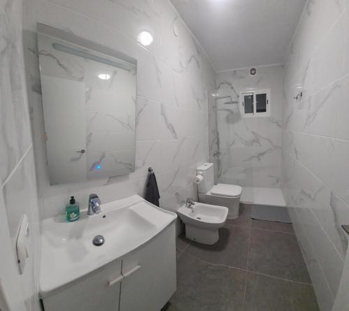 ein weißes Bad mit einem Waschbecken und einem WC in der Unterkunft EEB Room HABITACIÓN PRIVADA EN PISO COMPARTIDO in La Laguna