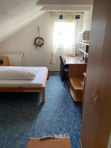 1 dormitorio con cama, escritorio y ventana en Gasthaus Rogge, en Lemgo