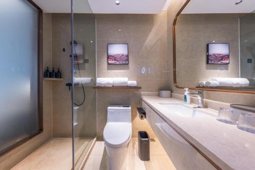 une salle de bain avec toilettes, lavabo et douche dans l'établissement Atour X Hotel Guangzhou Avenue South Canton Fair-Free shuttle bus to Canton Fair, à Canton