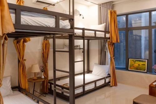a room with two bunk beds and a window at Phuoc Dat Riverside Homestay Hoi An in Hoi An