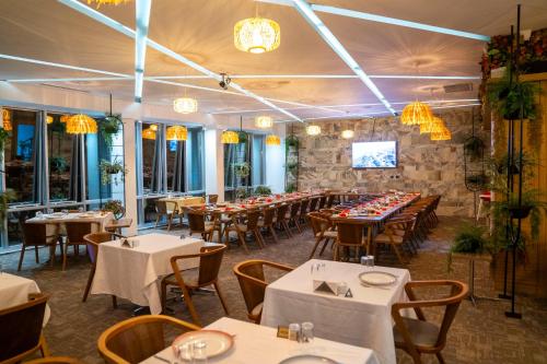 a dining room with tables and chairs and chandeliers at HALLEY OTEL in Denizli