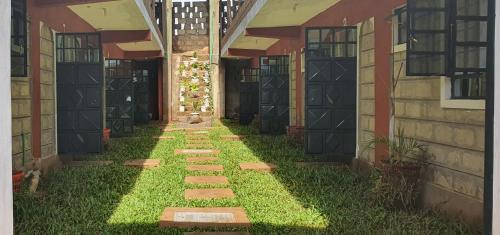 a walkway outside of a building with grass and weeds at Faraja in Meru