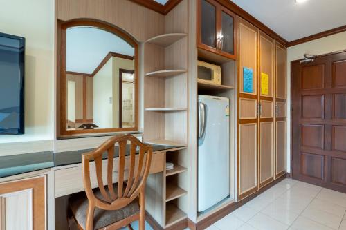 a kitchen with a chair and a refrigerator at La Casa South Pattaya Hotel in Pattaya South