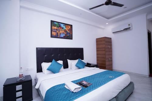 a bedroom with a large bed with blue pillows at Hotel Moon Taj Near Yashobhoomi Convention Centre in New Delhi