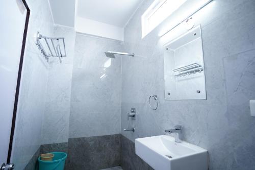 a white bathroom with a sink and a mirror at Hotel Moon Taj Near Yashobhoomi Convention Centre in New Delhi