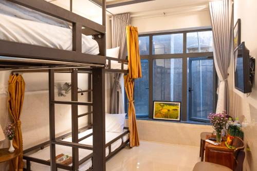 ein Schlafzimmer mit Etagenbetten in einem Hostel in der Unterkunft Phuoc Dat Riverside Homestay Hoi An in Hoi An