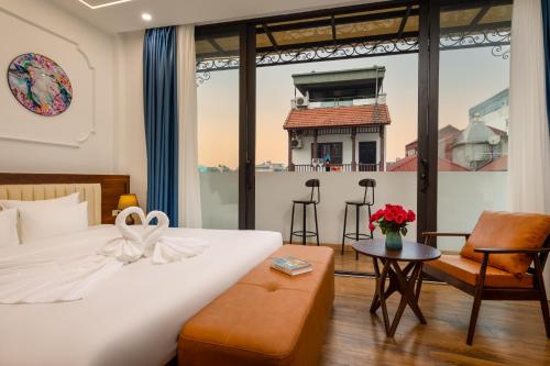 Casa Valentina Hanoi Hotel في هانوي: غرفه فندقيه بسرير وكرسي ونافذه