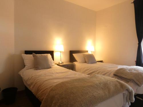 dos camas sentadas una al lado de la otra en una habitación en Central 2-bed flat in Edinburgh, en Edimburgo